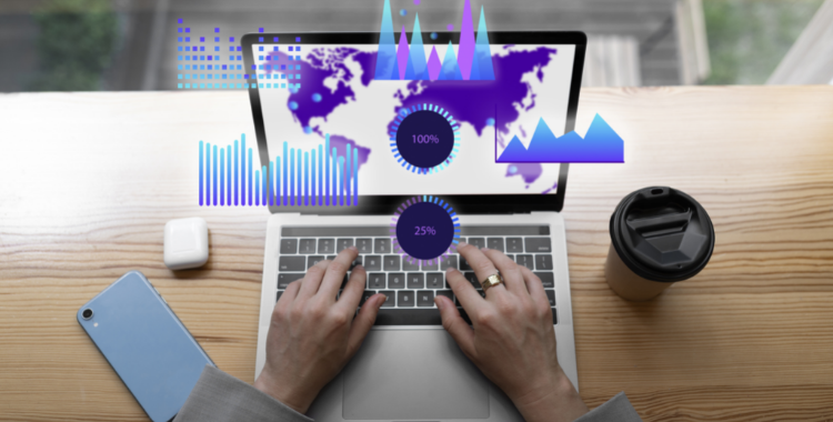 análise de dados no marketing | na foto uma pessoa usando o computador com gráficos saindo da tela, celular na mesa e também um copo de café